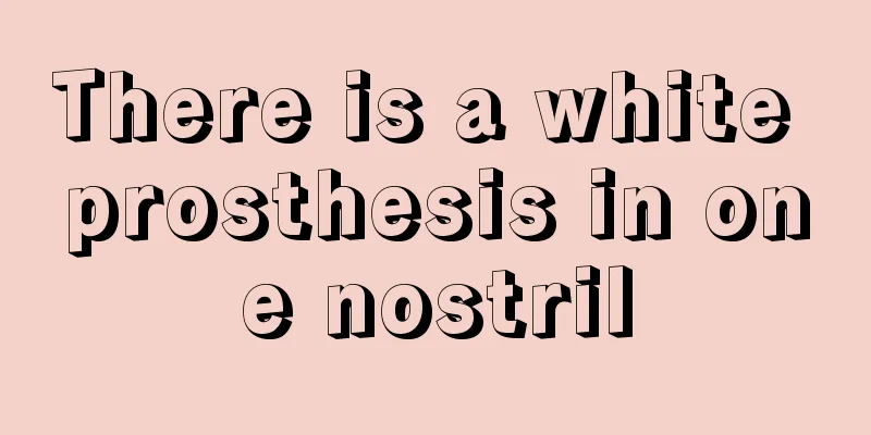 There is a white prosthesis in one nostril